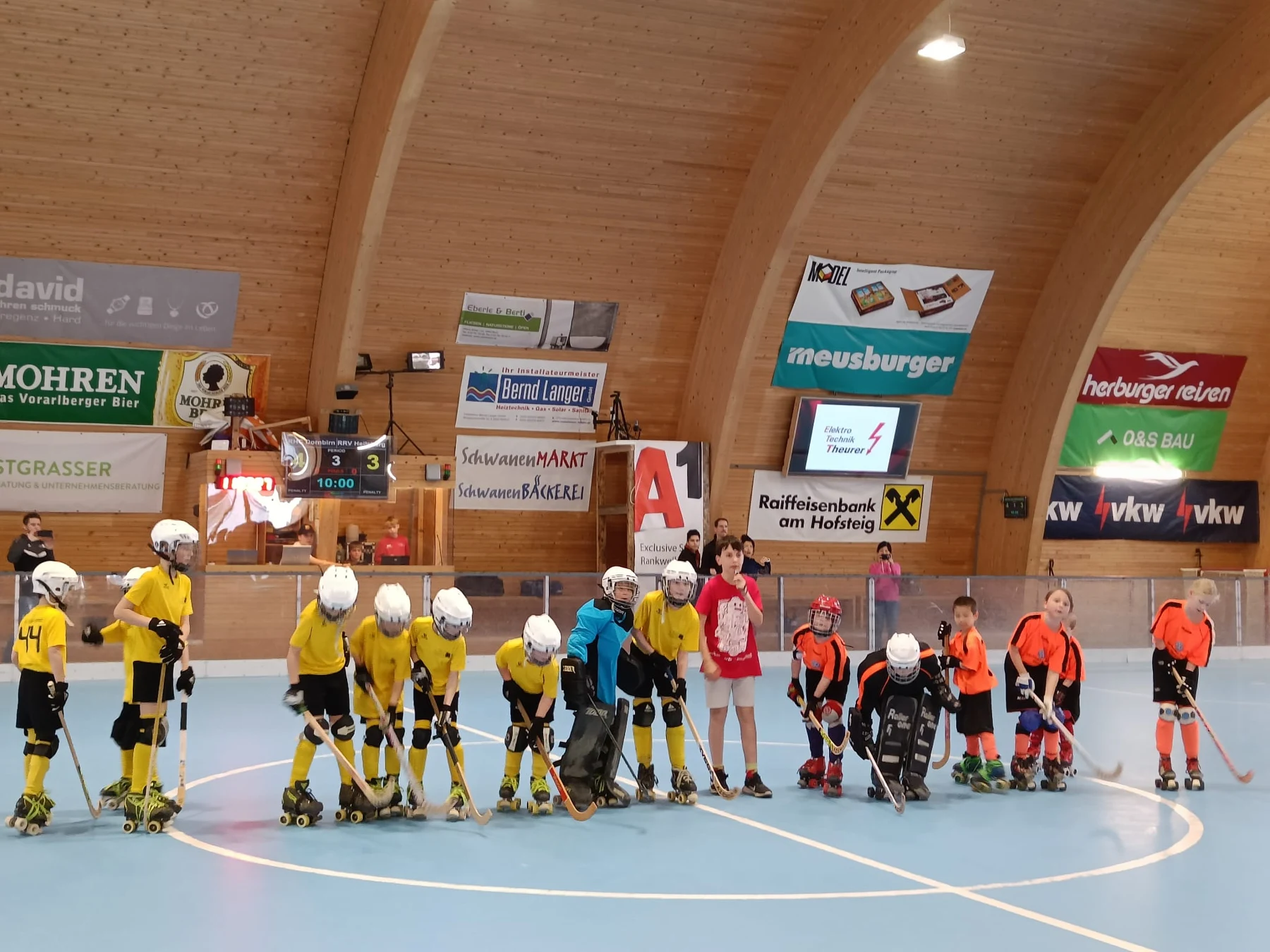 Kinder verschiedener Vereine stehen beim Rollhockeyspieltag gemeinsam auf dem Feld