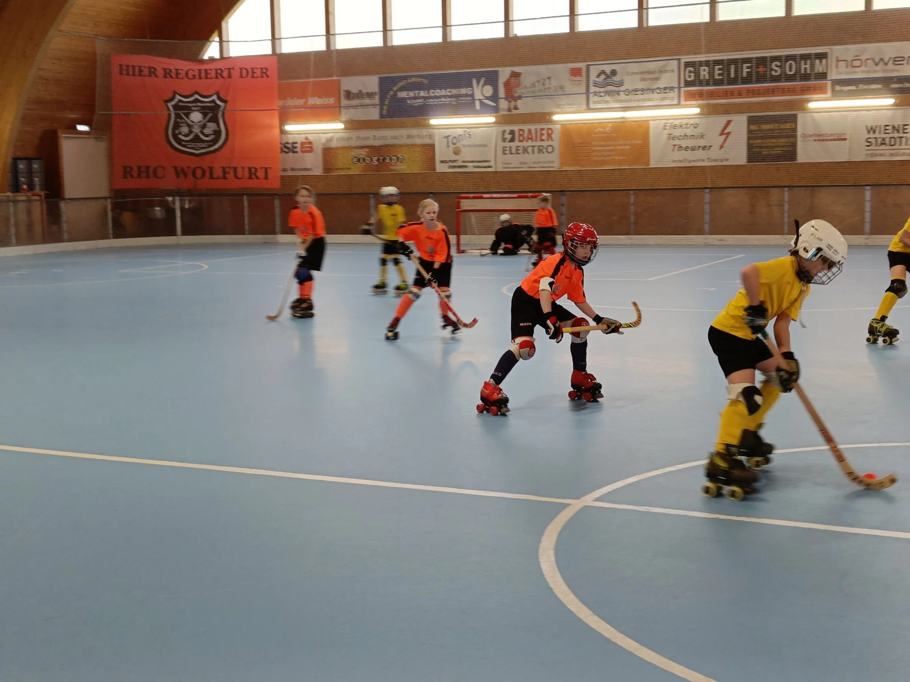 Junge Rollhockeyspieler mit Schläger und Ball im gemeinsamen Spiel